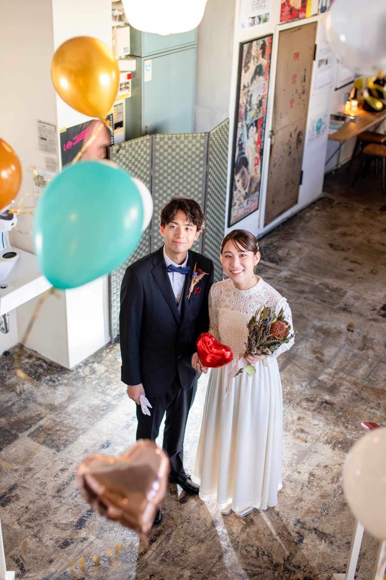 バルーンの間で微笑む洋装の新郎新婦